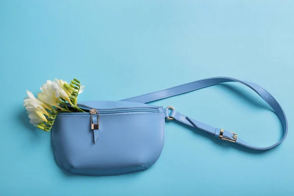 Composição de leigos plana com bolsa feminina elegante e flores de primavera no fundo de cor — Fotografia de Stock