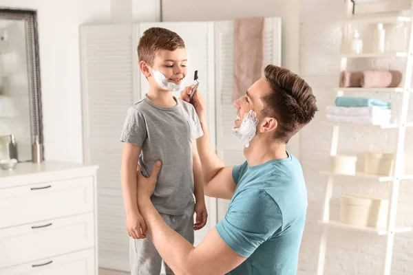 Papa pretenderen om zijn kleine zoon in badkamer te scheren — Stockfoto