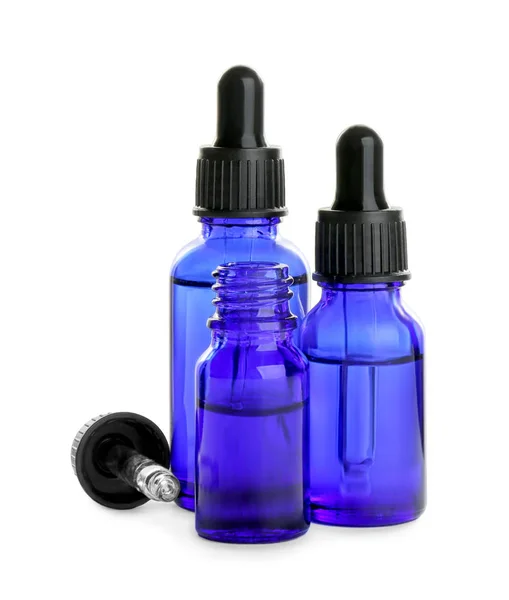 Kleine blaue Flaschen mit ätherischen Ölen auf weißem Hintergrund — Stockfoto