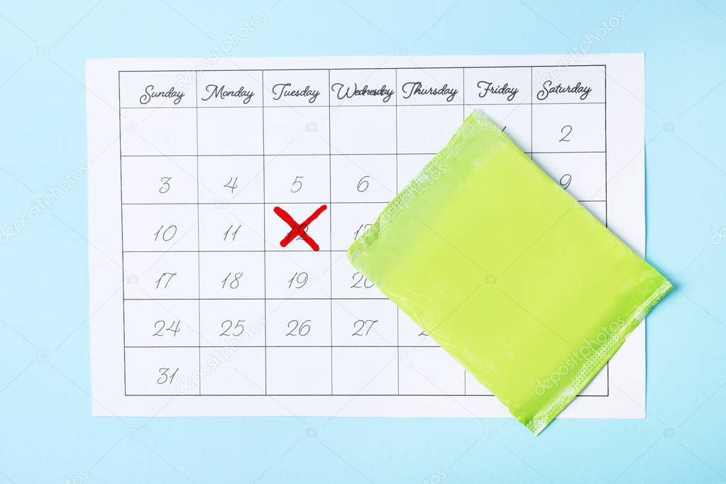 Calendar and menstrual pads on color background, top view. Gynecological care