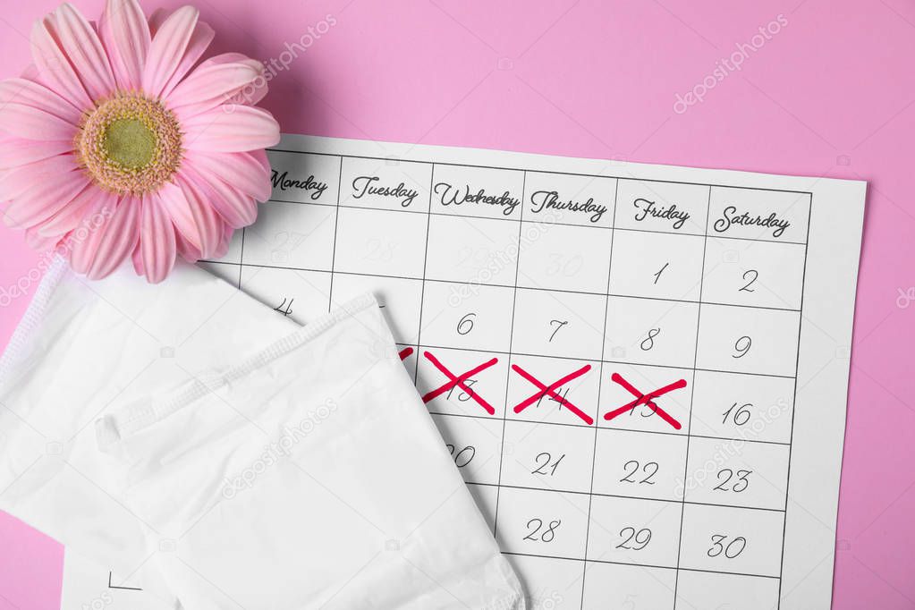 Flat lay composition with calendar, menstrual pads and gerbera flower on color background. Gynecological care