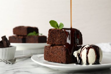 Taze brownies üzerine dökülen sos plaka, metin için alan dondurma ile servis. Lezzetli çikolatalı pasta