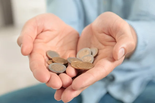 Человек держит монеты в руках в помещении, крупным планом — стоковое фото