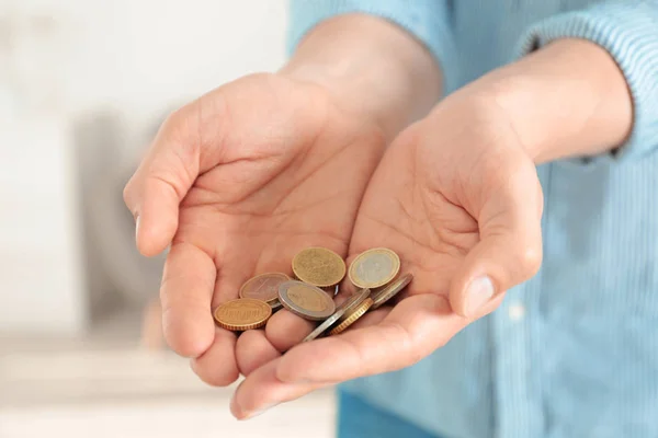 Hombre sosteniendo monedas en las manos en el interior, primer plano — Foto de Stock