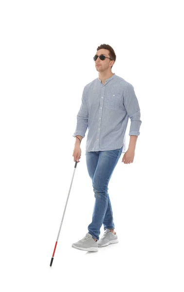 Young blind person with long cane walking on white background — Stok fotoğraf