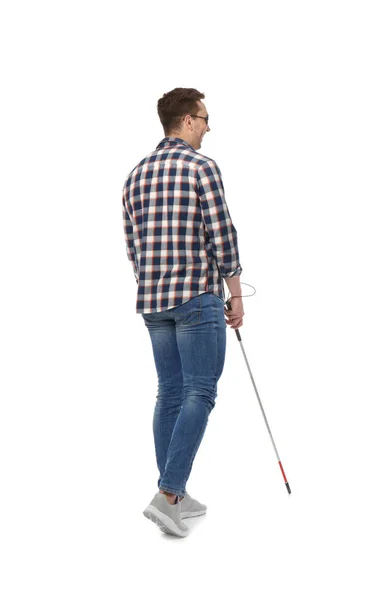 Young blind person with long cane walking on white background — Stok fotoğraf