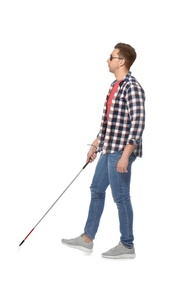 Young blind person with long cane walking on white background — Stok fotoğraf