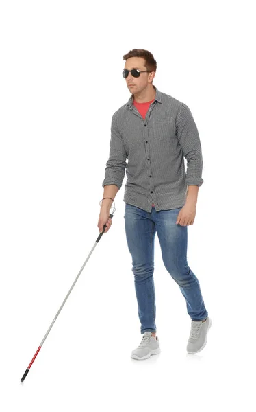 Young blind person with long cane walking on white background — Stok fotoğraf