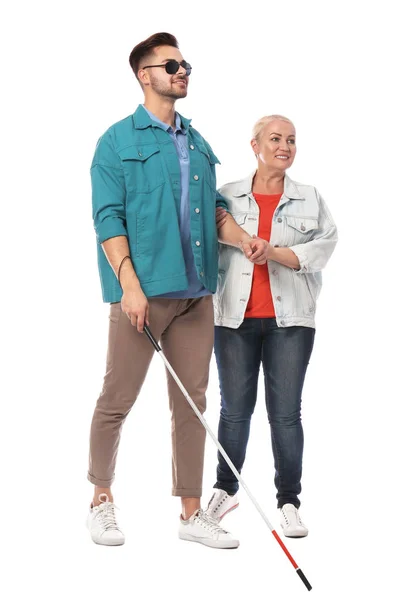 Mujer madura ayudando a una persona ciega con bastón largo sobre fondo blanco — Foto de Stock