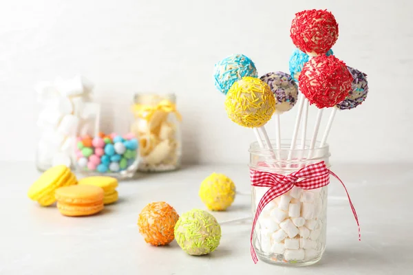 Yummy bright cake pops in glass jar full of marshmallows on table. Space for text — 스톡 사진