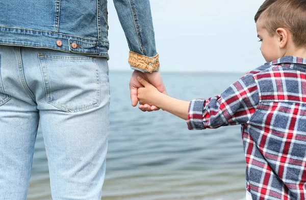 Malé milé dítě, které se drží za ruce s otcem u řeky. Rodinný čas — Stock fotografie