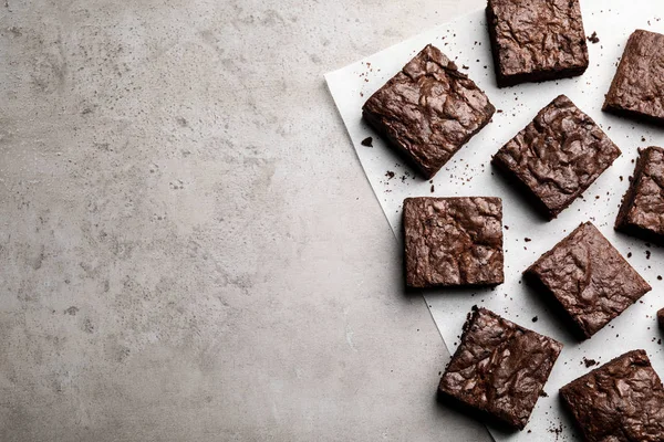 Composición plana con brownies frescos y espacio para texto sobre fondo gris. Delicioso pastel de chocolate —  Fotos de Stock