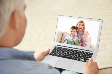 Evde görüntülü sohbet yoluyla aile üyeleri ile konuşurken üst düzey adam Closeup görünümü 