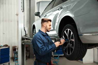 Otomobil tamirhanesinde otomobille çalışan teknisyen