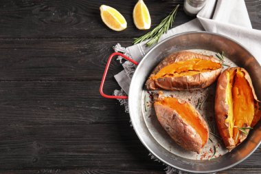 Ahşap arka plan üzerinde çanak pişmiş tatlı patates ile Düz yatıyordu kompozisyon. Metin için alan
