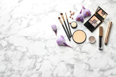 Birçok farklı makyaj ürünleri ve mermer arka plan üzerinde bahar çiçekleri, düz yatıyordu. Metin için alan