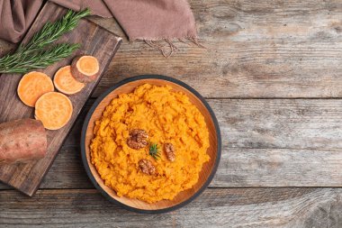 Flat lay composition with mashed sweet potatoes on wooden background, space for text clipart