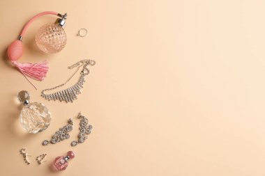 Renk arka plan üzerinde parfüm şişeleri ve mücevher ile Kompozisyon, düz yatıyordu. Metin için alan