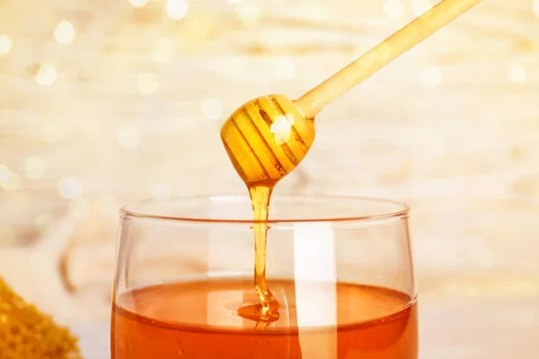Dulce miel goteando de cazo en tarro, primer plano — Foto de Stock