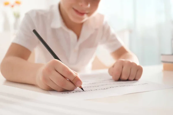 Ragazzino che scrive note musicali a tavola, primo piano — Foto Stock