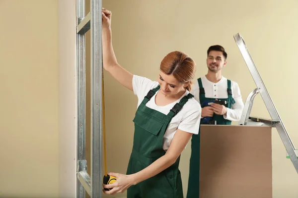 Arbeiter, die Trockenbauarbeiten in Innenräumen durchführen. Reparaturservice zu Hause — Stockfoto