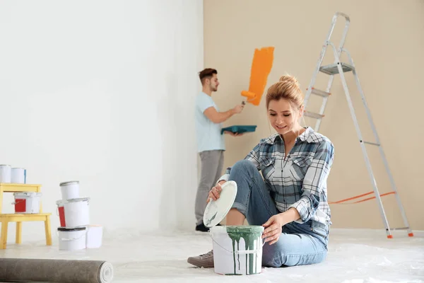 Pareja feliz pintando la pared adentro. Reparación casera — Foto de Stock