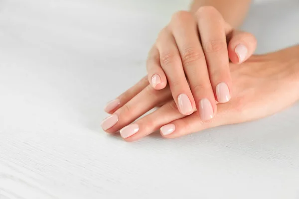 Vista de cerca de la mujer con las manos lisas y manicura en la mesa, espacio para el texto. Tratamiento de spa — Foto de Stock