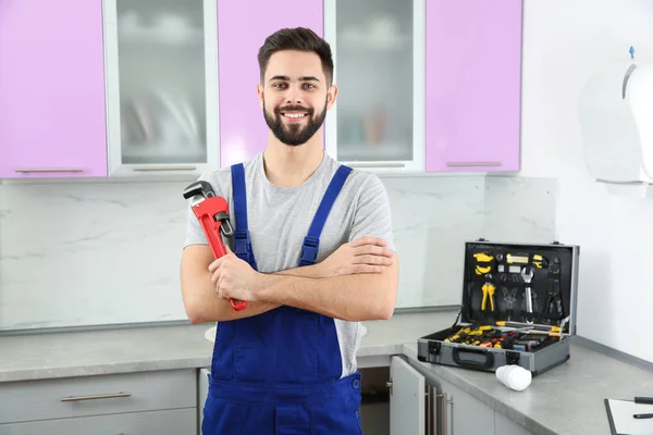 Plomero masculino con llave de tubo en la cocina. Servicio de reparación — Foto de Stock