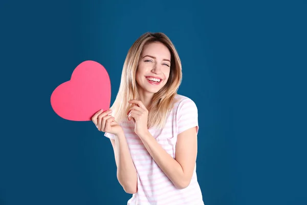 Ritratto di bella donna con scatola regalo a forma di cuore su sfondo colore — Foto Stock