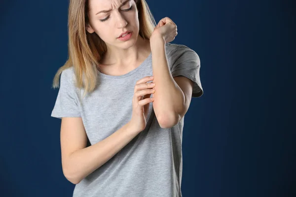 Woman scratching forearm on color background. Allergy symptom — 스톡 사진
