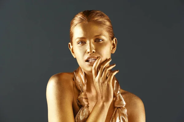 Porträt der schönen Dame mit Goldfarbe auf der Haut vor grauem Hintergrund — Stockfoto