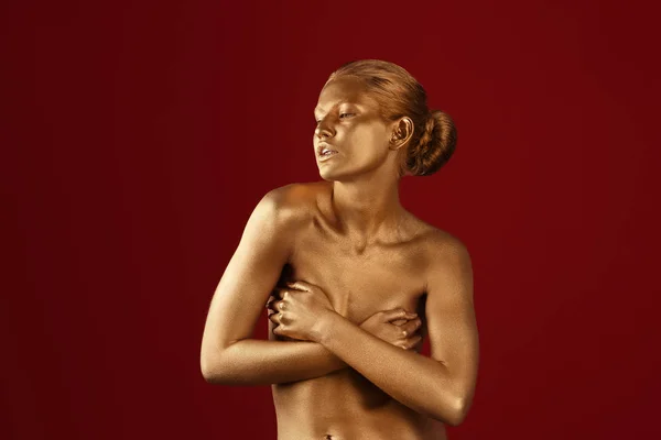 Porträt der schönen Dame mit Goldfarbe auf der Haut vor farbigem Hintergrund — Stockfoto