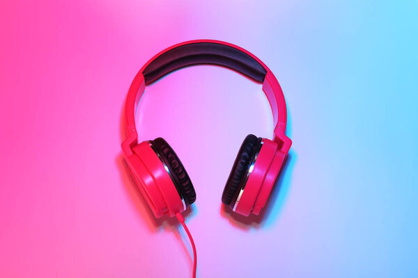 Stylish headphones on color background, top view