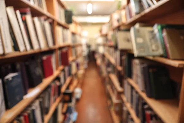 Vista borrosa de los armarios con libros en la biblioteca — Foto de Stock