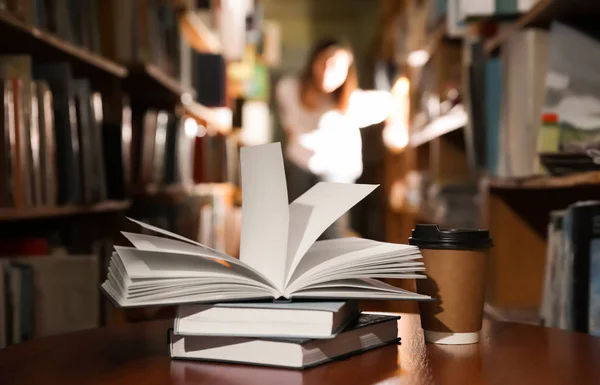 Libros y taza de café en la mesa de la biblioteca —  Fotos de Stock