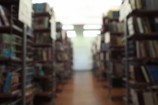 Vista borrosa de estanterías con libros en la biblioteca — Foto de Stock