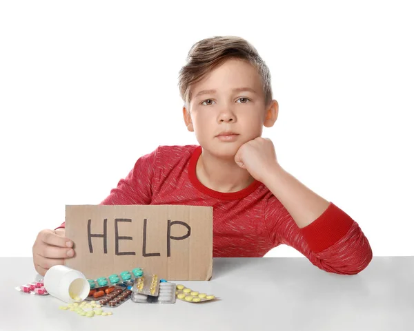 Little child with many different pills and word Help written on cardboard against white background. Danger of medicament intoxication — Stock Photo, Image