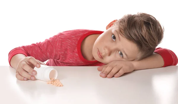 Criança com comprimidos no fundo branco. Perigo de intoxicação medicamentosa — Fotografia de Stock
