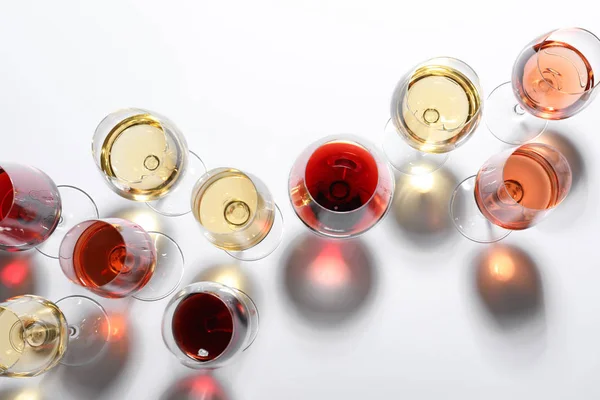 Bicchieri diversi con vino su sfondo bianco, vista dall'alto — Foto Stock