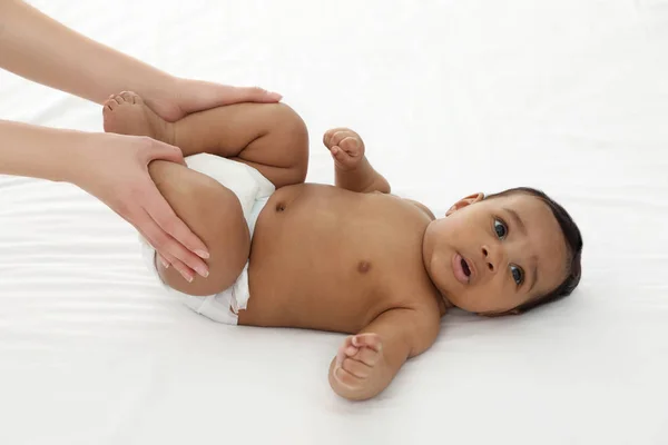 Madre e il suo bambino carino sul letto bianco. Massaggio ed esercizi per bambini — Foto Stock