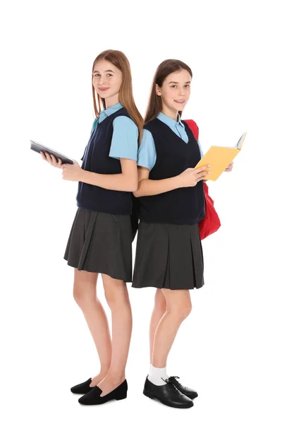 Retrato completo de chicas adolescentes en uniforme escolar con libros sobre fondo blanco —  Fotos de Stock