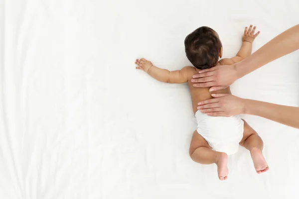 Beyaz yatakta anne ve onun sevimli çocuk üst görünümü, metin için alan. Bebek masajı ve egzersizleri — Stok fotoğraf