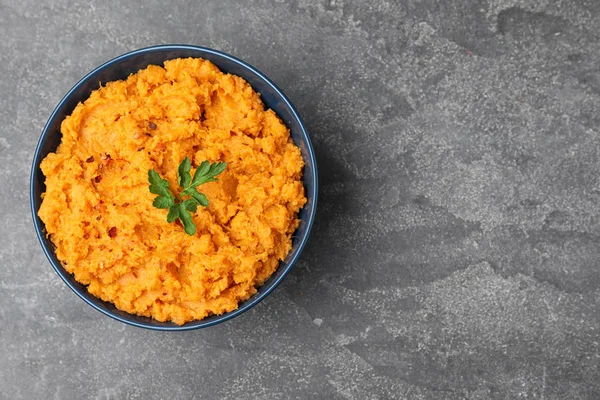 Bowl with mashed sweet potatoes on grey background, top view. Space for text — Stock Photo, Image