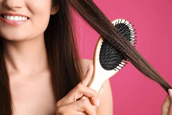 Woman with hair brush on color background, closeup — Stock Photo, Image