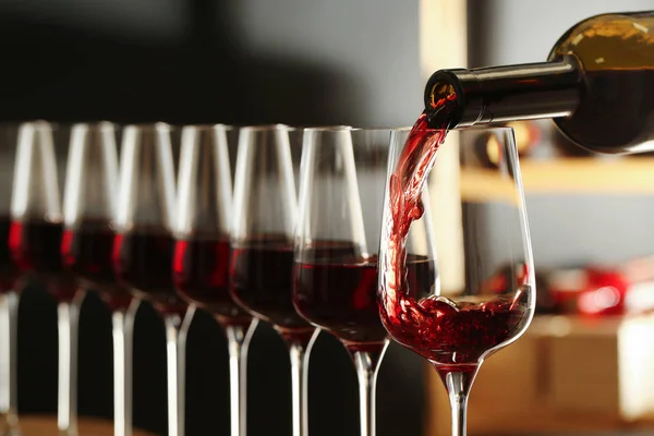 Pouring wine from bottle into glass in cellar, closeup — Stock Photo, Image
