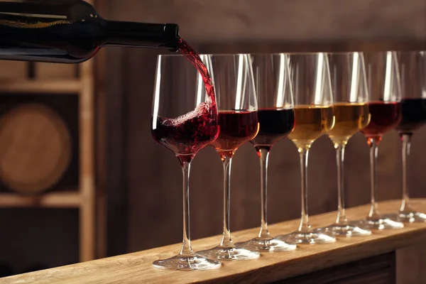 Наливание вина из бутылки в бокал в подвале — стоковое фото