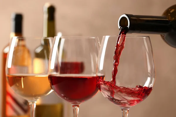 Verter el vino de la botella en un vaso sobre un fondo borroso, de cerca — Foto de Stock