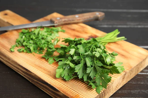 Wooden board with fresh green parsley and knife on table, closeup — 스톡 사진