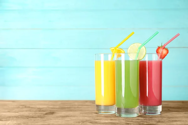 Three glasses of different juices with straws on table. Space for text — Stock Photo, Image