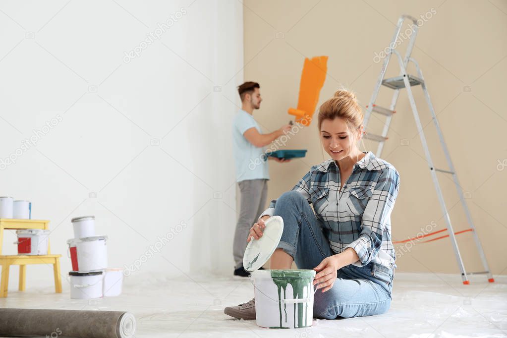 Happy couple painting wall indoors. Home repair